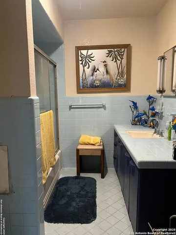 a bathroom with a tub sink and mirror
