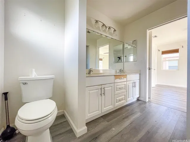 a bathroom with a granite countertop toilet sink and mirror