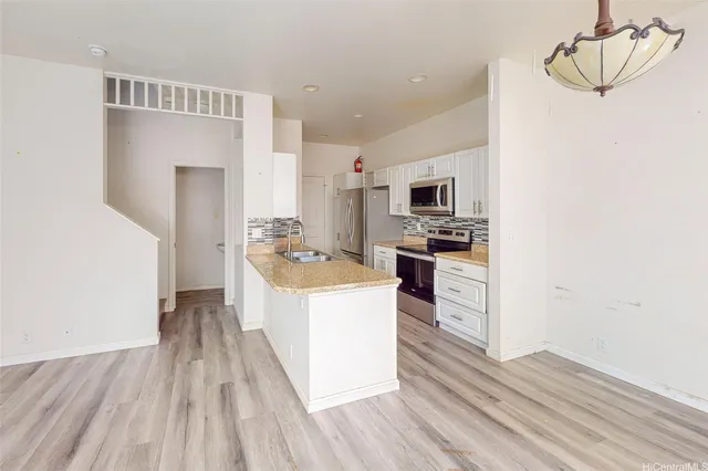 a kitchen with a sink a counter top space stainless steel appliances and cabinets