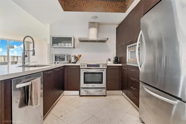 a kitchen with stainless steel appliances granite countertop a refrigerator and a sink