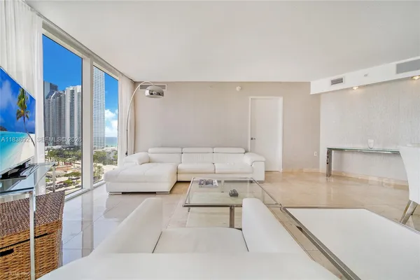 a living room with furniture and large windows