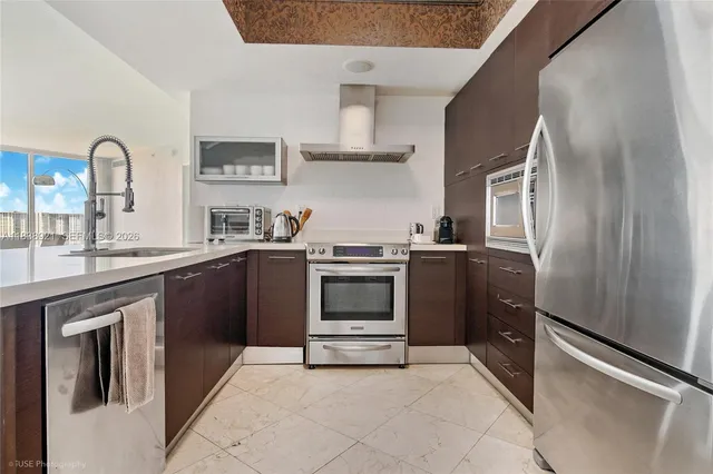 a kitchen with stainless steel appliances granite countertop a refrigerator and a sink