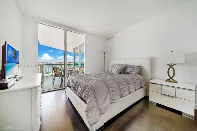 a bedroom with a bed window and a flat screen tv