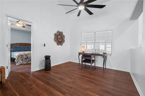a bedroom with a bed a dresser and wooden floor