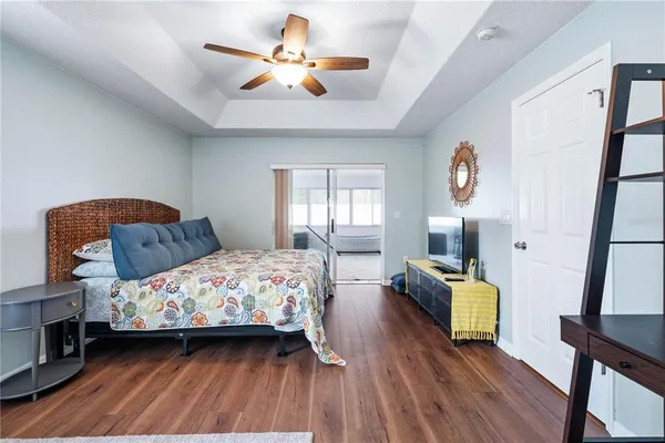 a bedroom with a bed a dresser and wooden floor