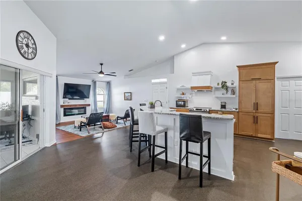 a kitchen with stainless steel appliances kitchen island granite countertop a table and chairs