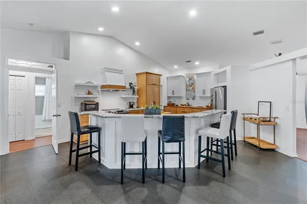 a kitchen with a refrigerator a microwave oven a sink dishwasher and wooden cabinets with wooden floor