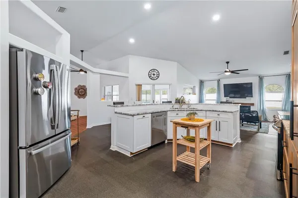 a kitchen with granite countertop a sink appliances cabinets and counter space