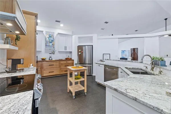 a kitchen with cabinets stainless steel appliances and a window