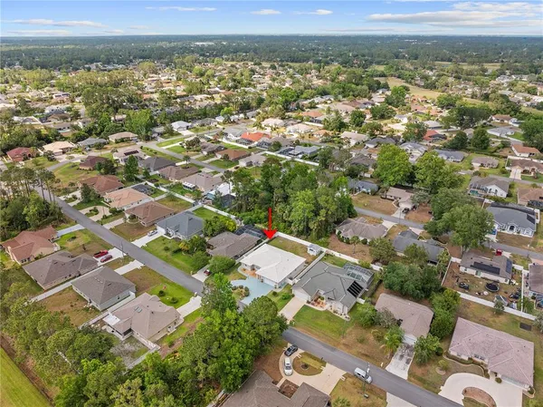 an aerial view of a house with swimming pool and mountains