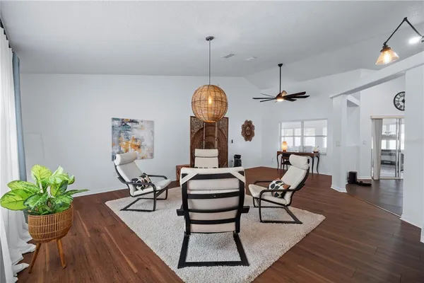 a dining room with furniture potted plants and wooden floor