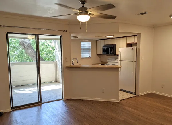 a kitchen with kitchen island wooden floor and a refrigerator