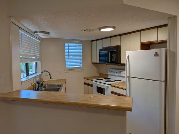 a kitchen with refrigerator cabinets and wooden floor