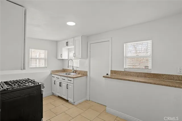 a kitchen with stainless steel appliances granite countertop a sink stove and cabinets