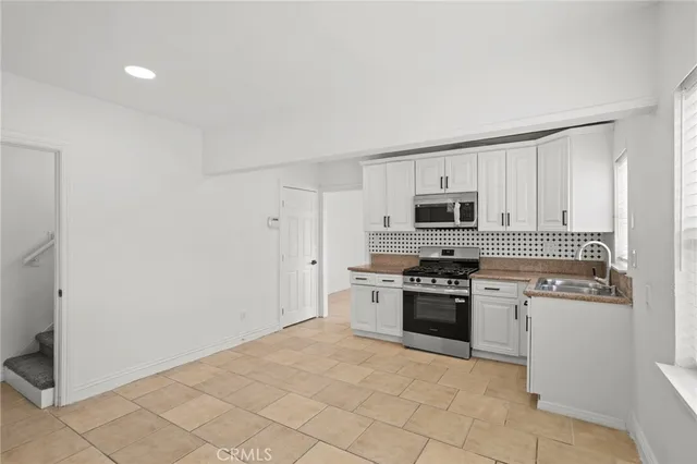 a kitchen with a stove top oven and cabinets