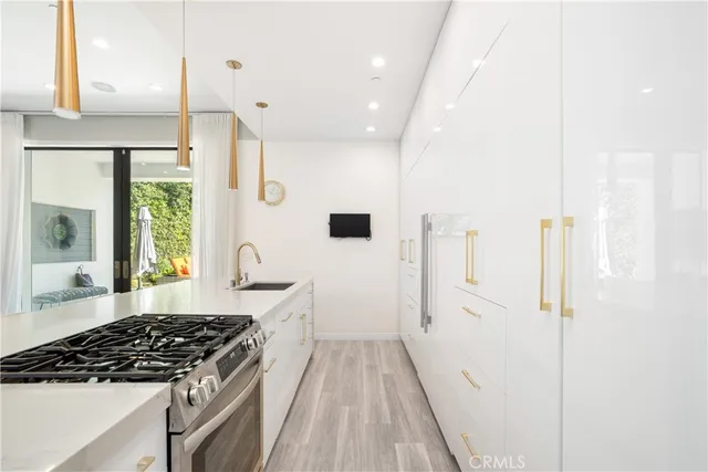 a large white kitchen with a sink and a refrigerator