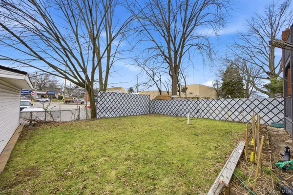 a view of a yard with wooden fence
