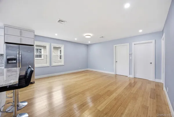 a view of empty room with wooden floor and windows