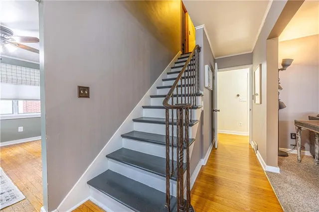 a view of a hallway with wooden floor and staircase