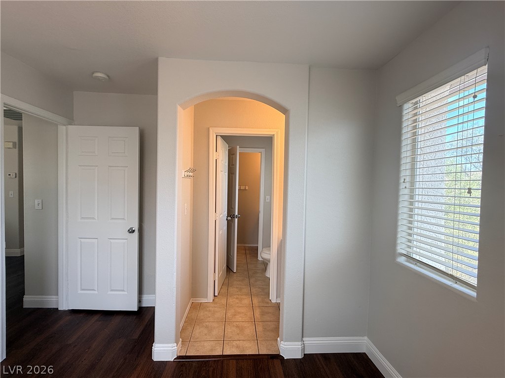 11953 Fairfax Ridge Street Las Vegas, NV 89183 - Photo 20 of 32 An inviting archway separates warm wood flooring from cool tile, leading to a bright, well-appointed bathroom.