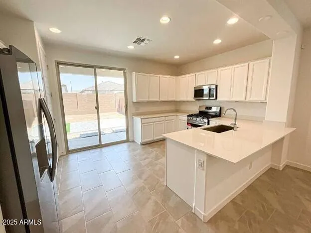 a kitchen with a refrigerator a sink and cabinets