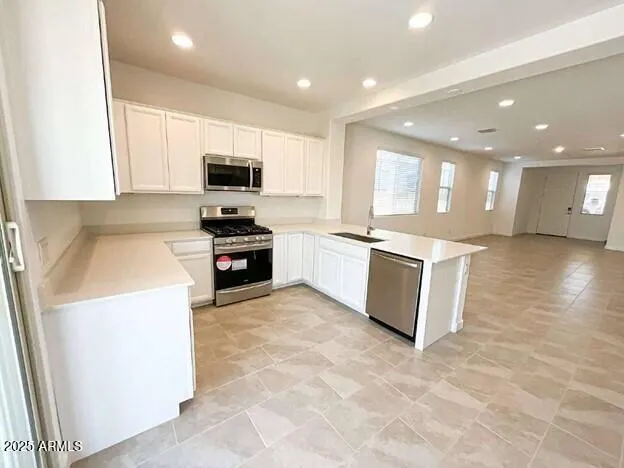 a kitchen with stainless steel appliances granite countertop a stove top oven a sink a counter top space and cabinets