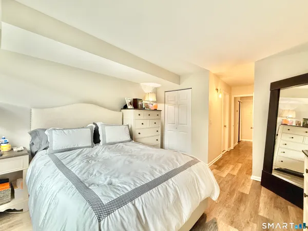 a bedroom with a large bed and a flat tv screen on dresser