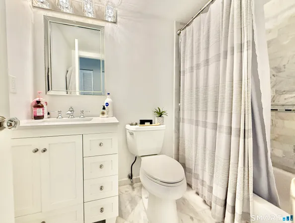 a bathroom with a sink a toilet and shower curtain