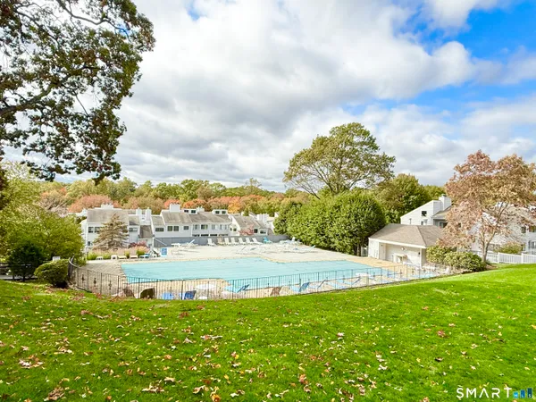a view of a house with a big yard and large trees