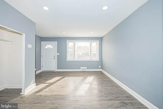 an empty room with windows and closet