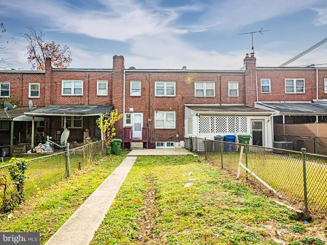 a view of a swimming pool with a lounge chairs in front of house