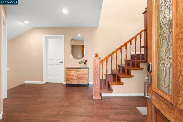 a view of entryway and hall with wooden floor