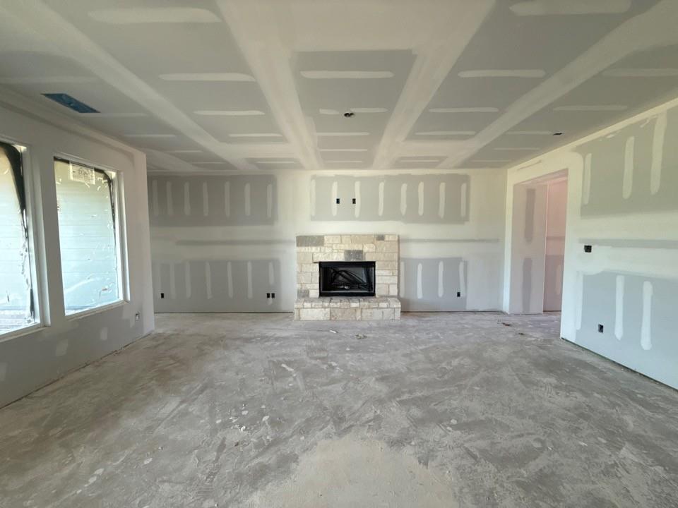 1224 Colca Drive Springtown, TX 76082 - Photo 5 of 8 Spacious interior featuring a stone fireplace, coffered ceilings, and multiple large windows