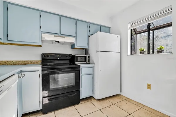 a white refrigerator freezer and a stove sitting inside of a kitchen