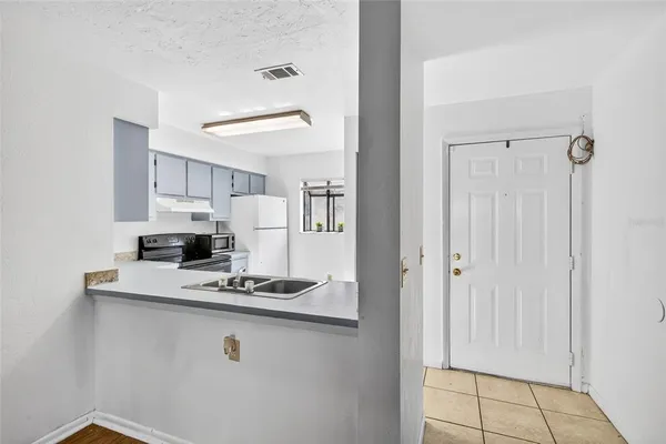 a kitchen with kitchen island white cabinets and refrigerator