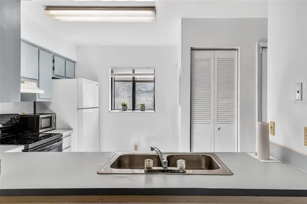 a kitchen with a sink and a refrigerator
