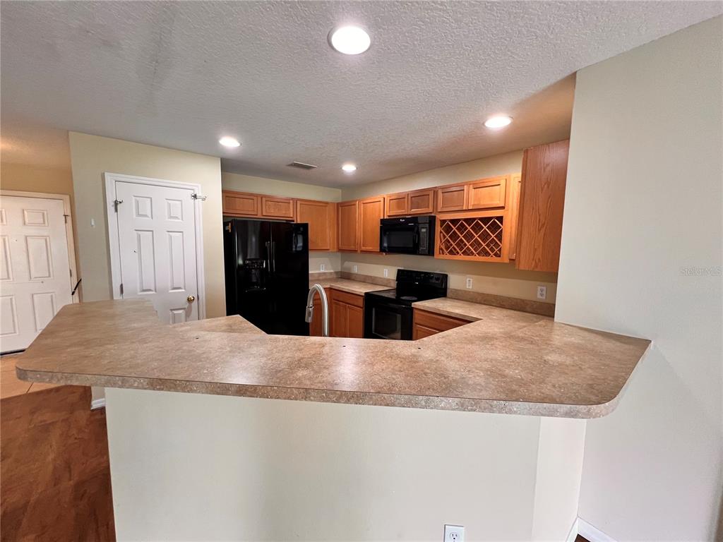 2476 Hassonite Street Kissimmee, FL 34744 - Photo 2 of 8 a large kitchen with kitchen island a sink stainless steel appliances and cabinets