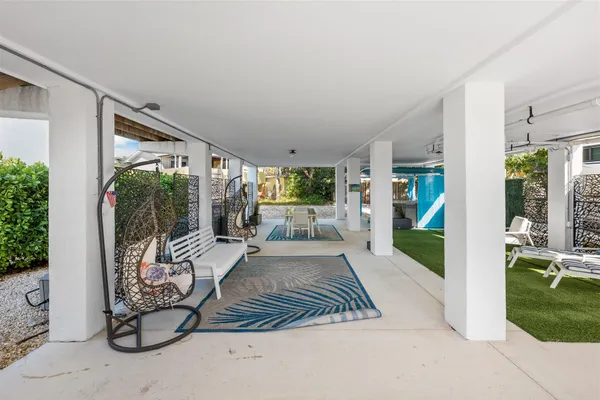 a view of a patio with table and chairs potted plants with floor to ceiling window