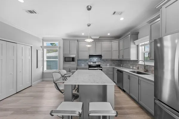 a large kitchen with kitchen island a dining table and chairs