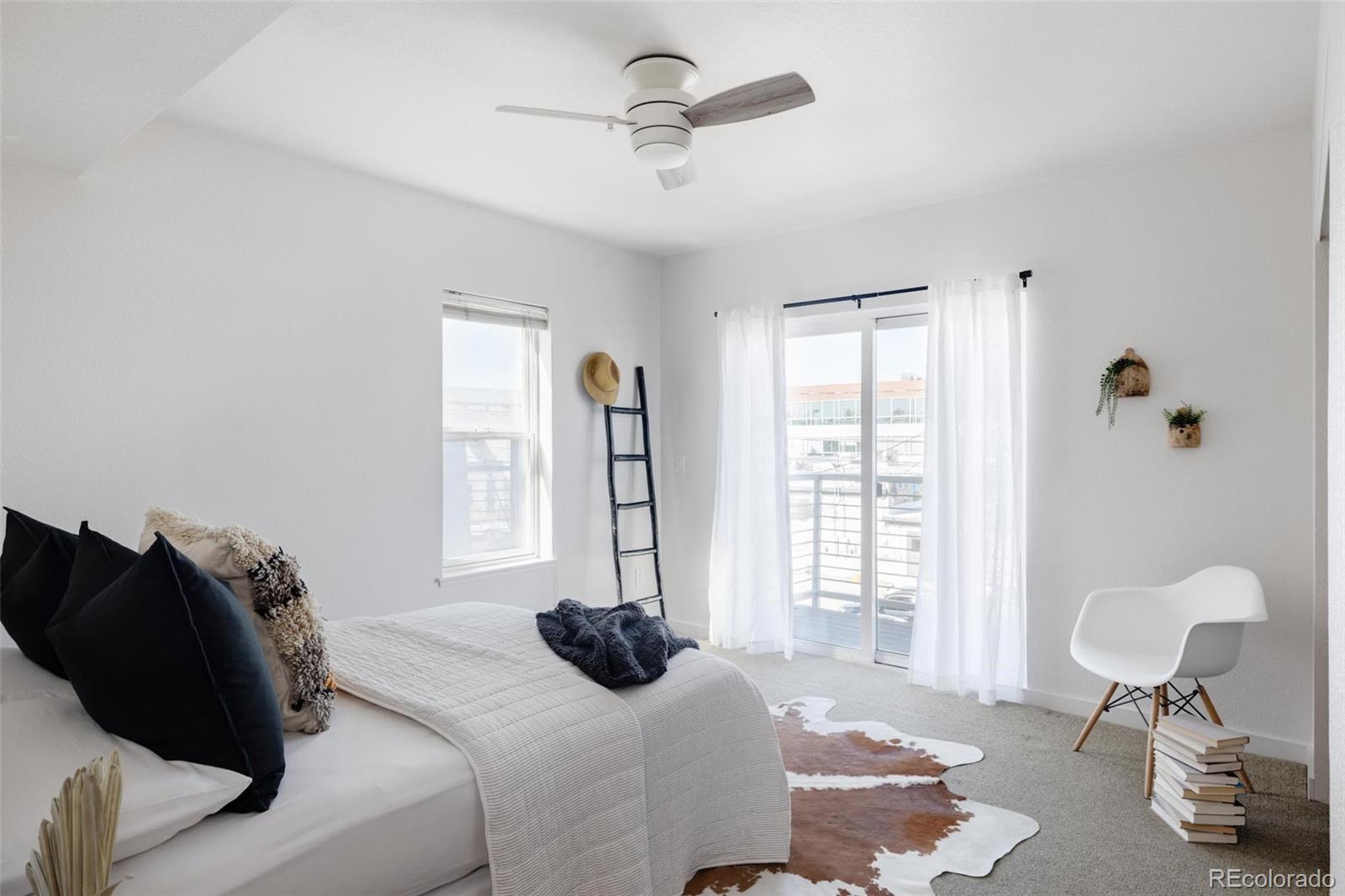 2999 Lawrence Street, Unit 202 Denver, CO 80205 - Photo 14 of 40 a bedroom with a bed and a chandelier