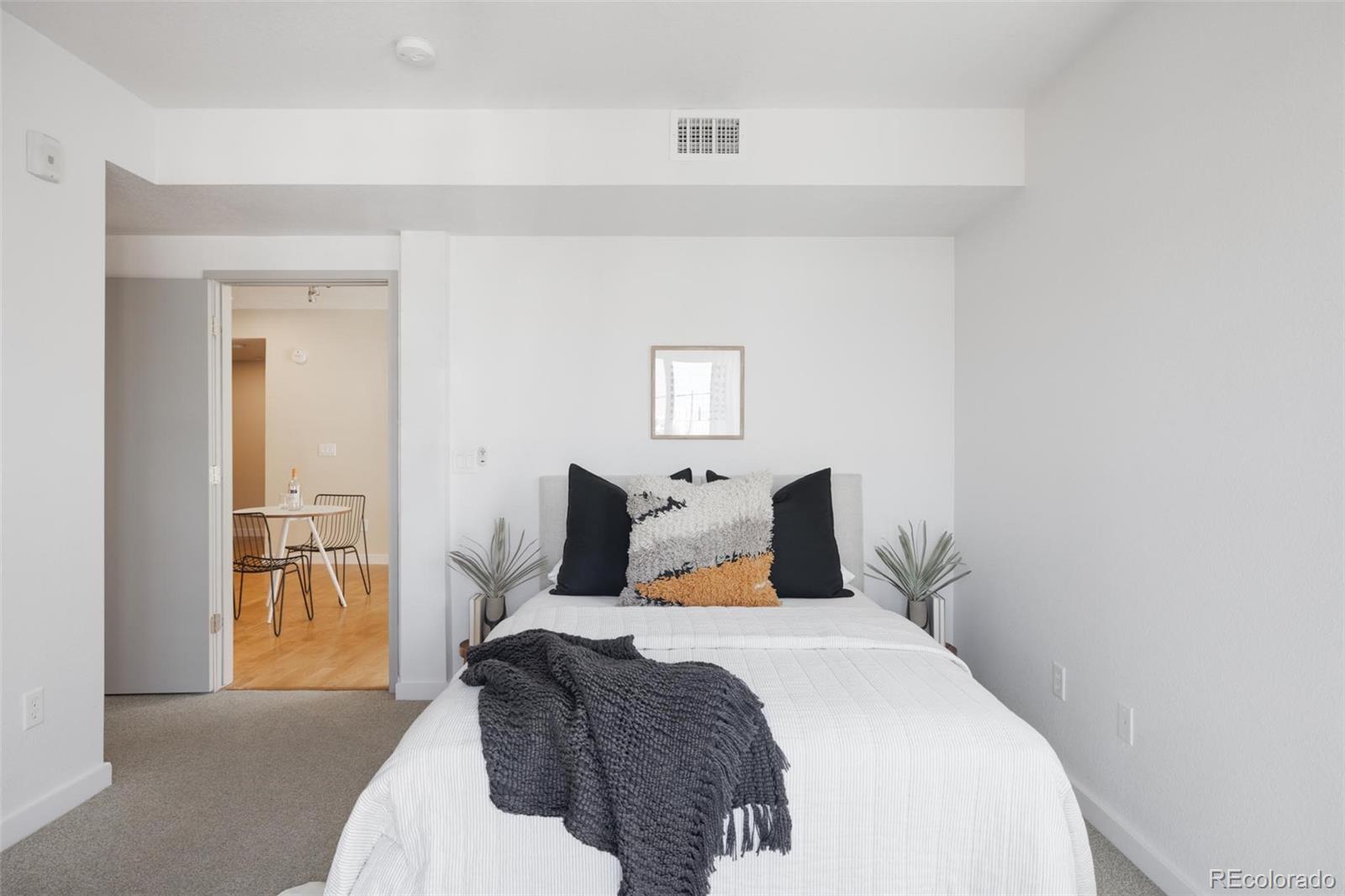 2999 Lawrence Street, Unit 202 Denver, CO 80205 - Photo 17 of 40 a bedroom with a large bed and a chandelier