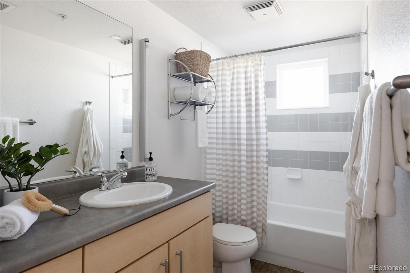 2999 Lawrence Street, Unit 202 Denver, CO 80205 - Photo 20 of 40 a bathroom with a granite countertop sink toilet and shower