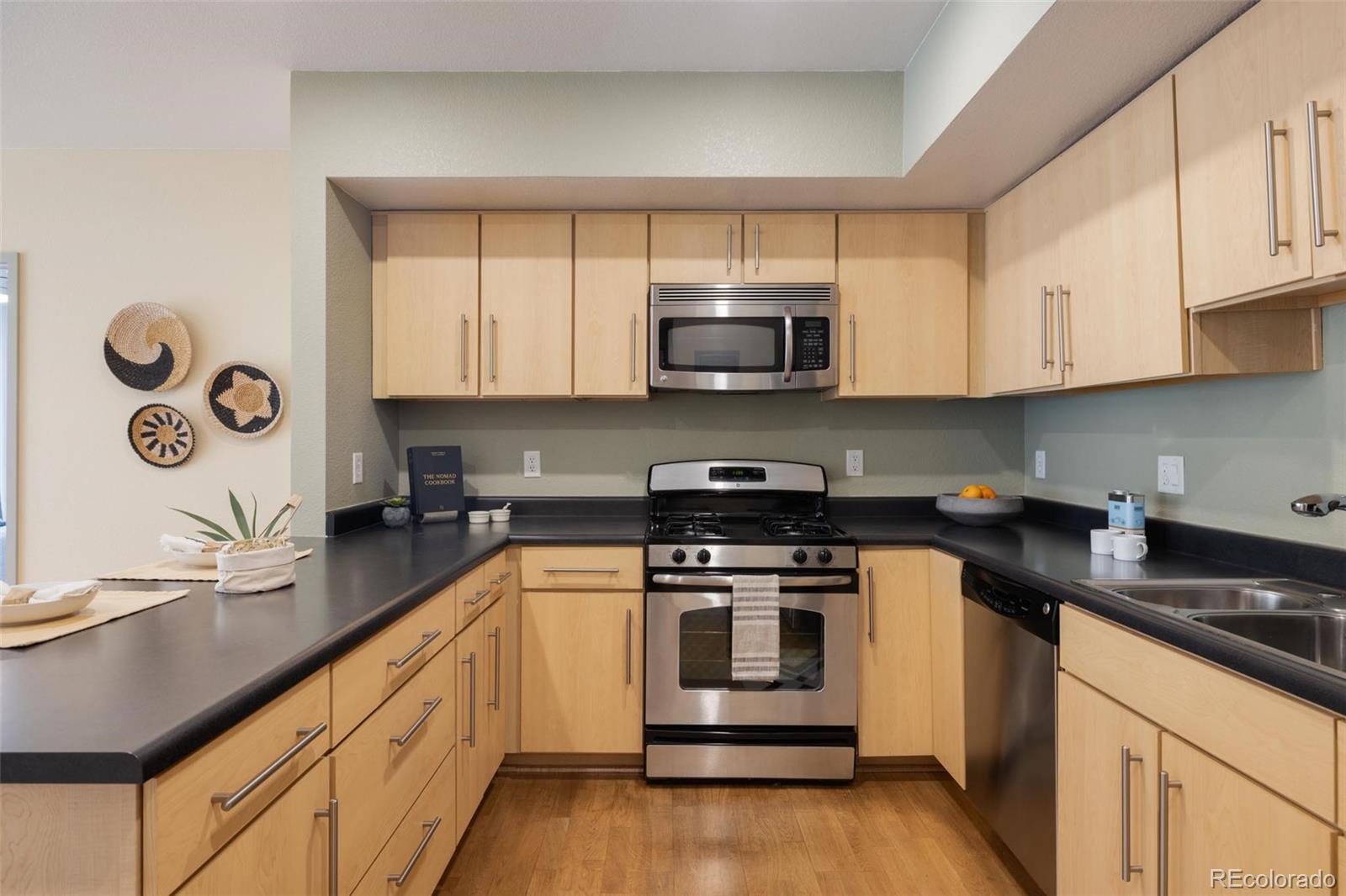 2999 Lawrence Street, Unit 202 Denver, CO 80205 - Photo 6 of 40 a kitchen with stainless steel appliances a stove a microwave sink and cabinets