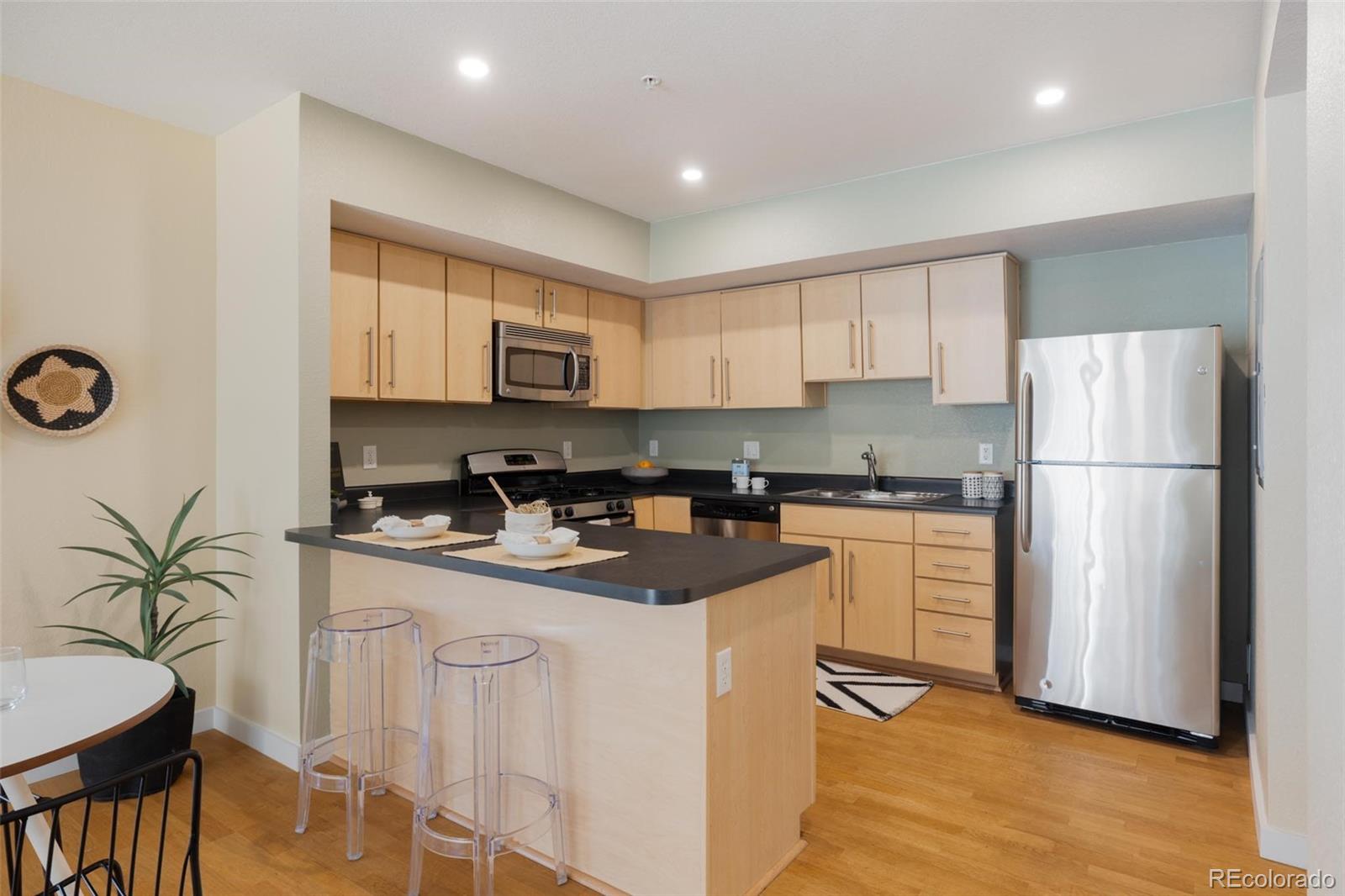 2999 Lawrence Street, Unit 202 Denver, CO 80205 - Photo 7 of 40 a kitchen with white cabinets and refrigerator