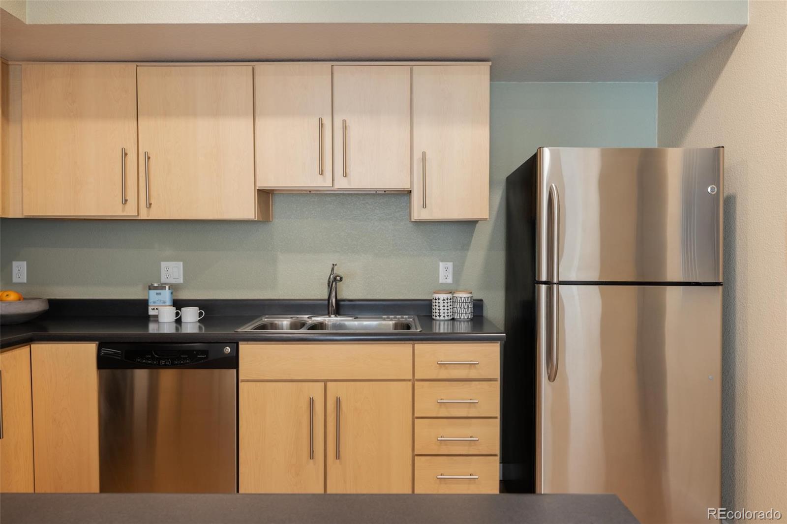 2999 Lawrence Street, Unit 202 Denver, CO 80205 - Photo 8 of 40 a kitchen with stainless steel appliances granite countertop a refrigerator sink and cabinets