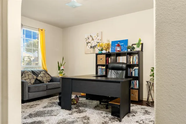 a view of a workspace with furniture and a window