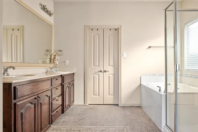 a spacious bathroom with a double vanity sink a mirror and a shower