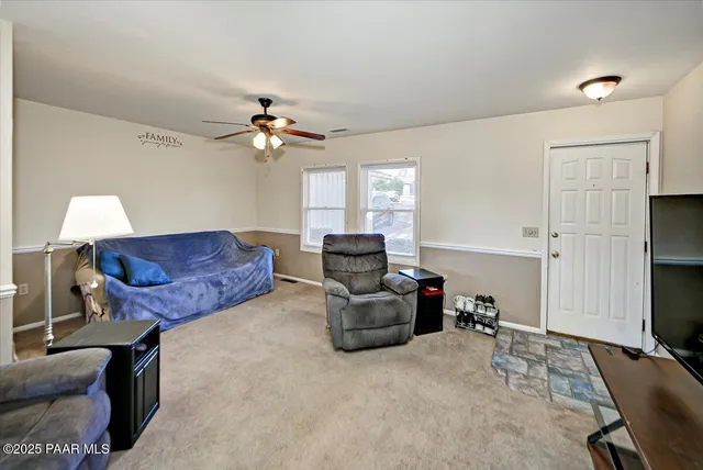 a living room with furniture a ceiling fan and a rug