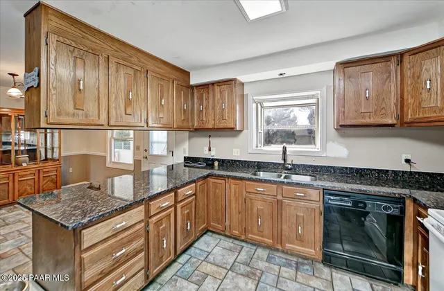 a kitchen with granite countertop a sink stove and cabinets