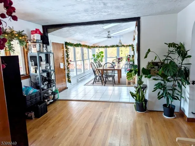 a dining room with furniture potted plants and wooden floor
